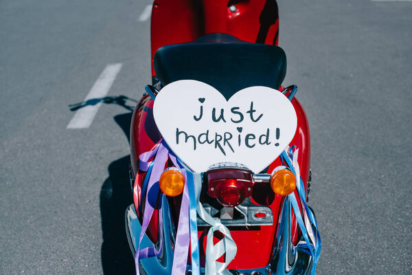 retro scooter with ribbons and "just married" heart symbol for wedding