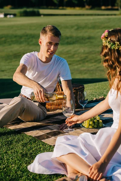 Felice Sposo Versando Vino Nel Bicchiere Giovane Sposa Sulla Coperta — Foto stock gratuita