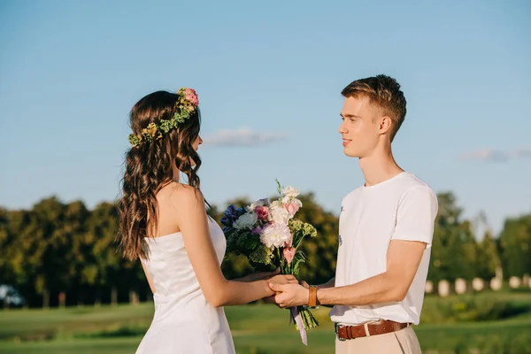 Elegantes Hochzeitspaar Händchen Haltend Und Blumenstrauß — kostenloses Stockfoto