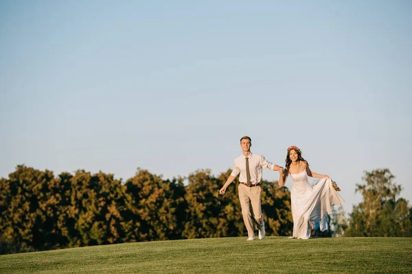 Красива Щаслива Молода Весільна Пара Біжить Зеленому Лузі Парку — стокове фото