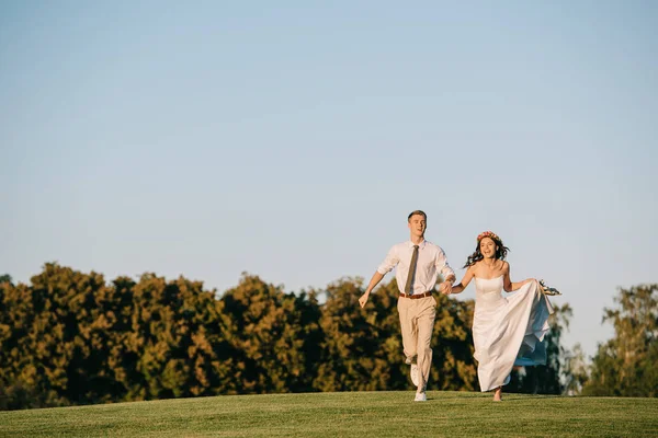 Ευτυχισμένος Γάμος Νεαρό Ζευγάρι Τρέχει Στο Πράσινο Λιβάδι Στο Πάρκο — Φωτογραφία Αρχείου
