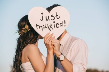 Genç düğün çift öpüşme ve kalp sadece evli yazıt ile tutarak 