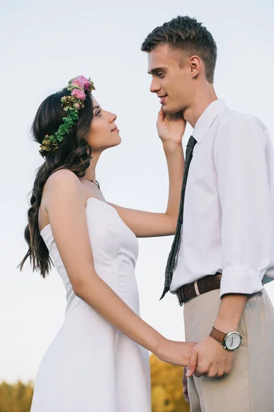 Schöne Romantische Junge Hochzeitspaar Händchen Haltend Und Einander Anschauend — kostenloses Stockfoto