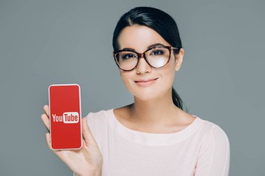 youtube Web sitesi ile smartphone gri izole ekranda gösterilen gözlük gülümseyen kadın portresi