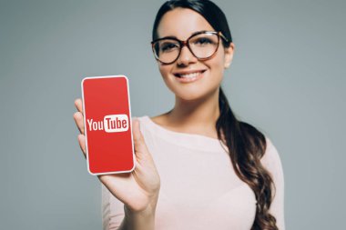 youtube cihazı, gri izole ile Smartphone sunulması güzel gülümseyen kız