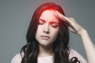 sick woman suffering from headache, with red painful point, isolated on grey