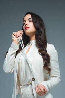 esmer kadının beyaz takım kolye, gri izole ile poz alttan görünüm 