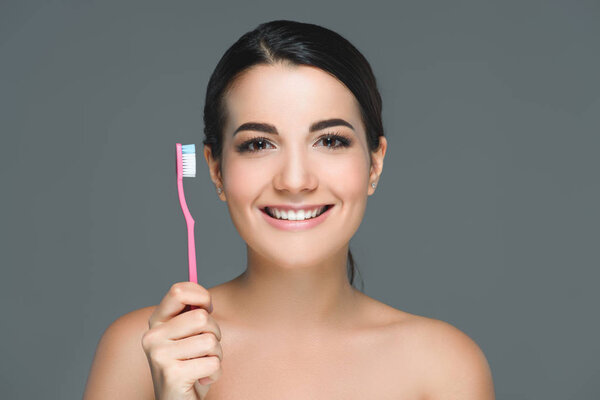 smiling brunette woman holding tooth brush in hand isolated on white