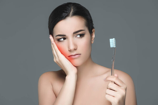 portrait of brunette woman with tooth brush having tooth ache isolated on grey