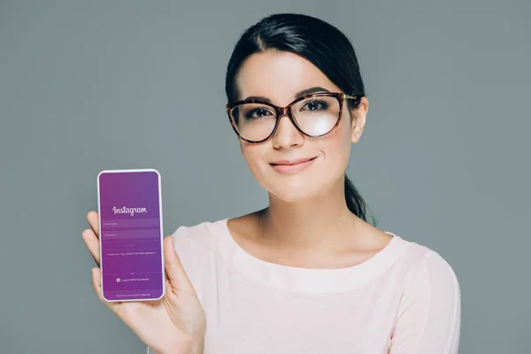 Portrait Smiling Woman Eyeglasses Showing Smartphone Instagram App Screen Isolated — Stock Photo, Image