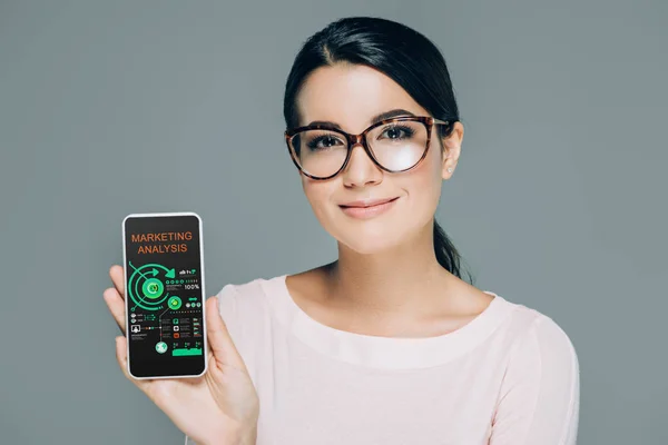 Portrait Smiling Woman Eyeglasses Showing Smartphone Marketing Analysis Screen Isolated — Stock Photo, Image