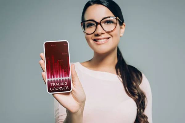 Vrouw Toont Smartphone Met Handel Cursussen Geïsoleerd Grijs — Stockfoto