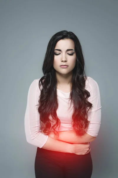 Vrouw Lijdt Aan Buikpijn Met Rode Pijnlijke Punt Geïsoleerd Grijs — Stockfoto