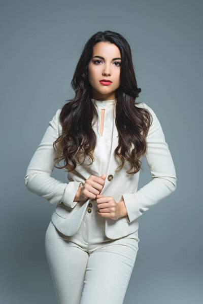 красивая элегантная женщина в белом костюме, изолированная на сером
