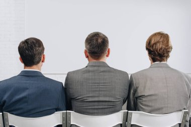 arkadan görünüşü hub eğitim sırasında sandalyelere oturan üç iş adamları
