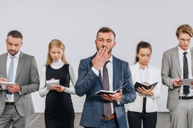 hub içinde iş adamları önünde esneme sırasında ağız kapsayan iş coach