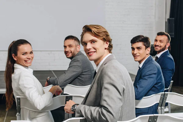 Lächelnde Geschäftsleute Sitzen Beim Training Hub Auf Stühlen Und Blicken — Stockfoto