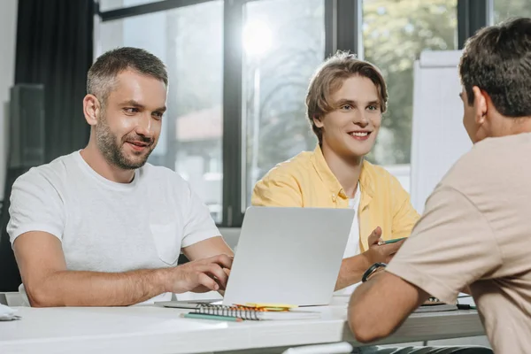 Glimlachende Zakenmensen Zittend Aan Tafel Tijdens Bijeenkomst Office — Stockfoto