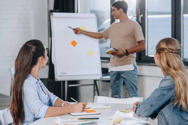 Flipchart üzerinde office sunum sırasında işaret eden işadamı