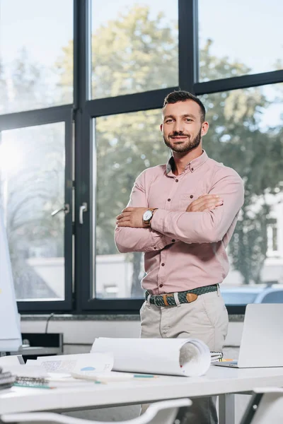 Lächelnder Gutaussehender Geschäftsmann Der Mit Verschränkten Armen Büro Steht Und — Stockfoto