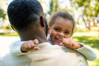 kamera onu parkta sarılma baba süre bakarak mutlu Afro-Amerikan kızı
