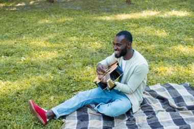 yakışıklı Afrikalı-Amerikalı gitarist Park akustik gitar çalmak