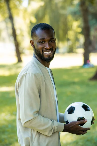 Sonriente Guapo Afroamericano Hombre Pie Con Pelota Fútbol Parque Mirando — Foto de stock gratuita