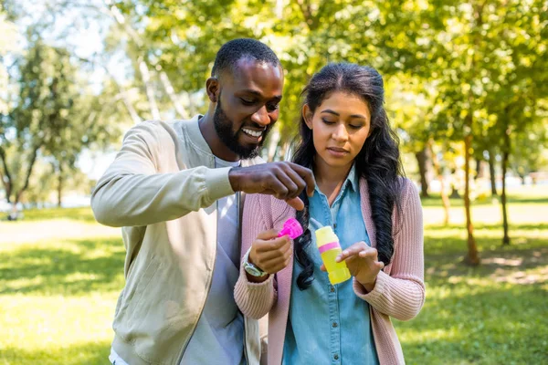 African American Couple Having Fun Bottle Soap Bubbles Park — Free Stock Photo