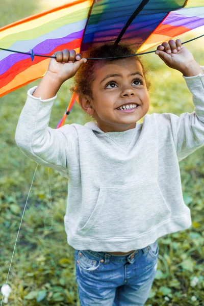 Başının Üstünde Gökkuşağı Uçurtma Park Holding Sevimli Afro Amerikan Çocuk — Stok fotoğraf