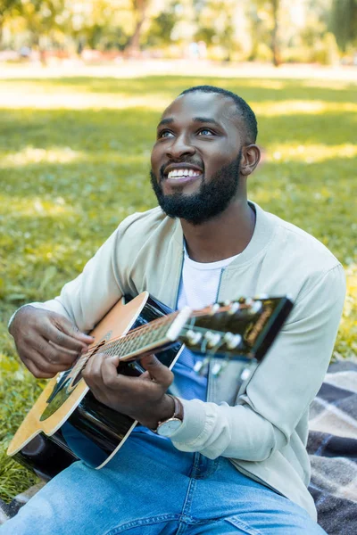 Щасливий Красивий Афроамериканський Чоловік Грає Акустичній Гітарі Парку Дивиться Вгору — Безкоштовне стокове фото