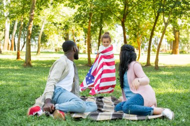 Afro-Amerikan kızı ayakta Park Amerikan bayrağı sarılı