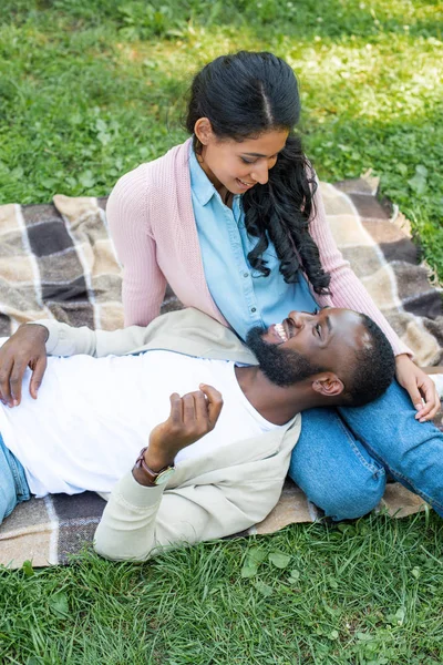 ハイアングルのガール フレンド公園で足の上に横たわる幸せなアフリカ系アメリカ人のボーイ フレンド — ストック写真