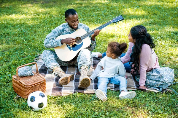 Lächelnder Afrikanisch Amerikanischer Soldat Militäruniform Spielt Gitarre Für Familie Park — Stockfoto