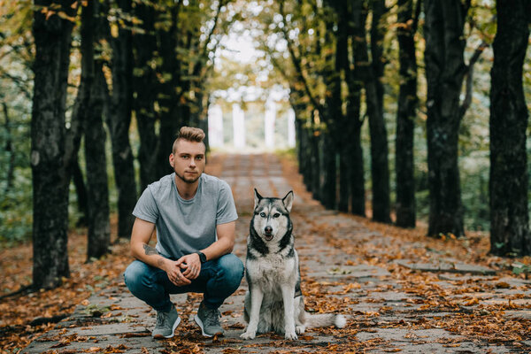 young man with husky dog in autumn park