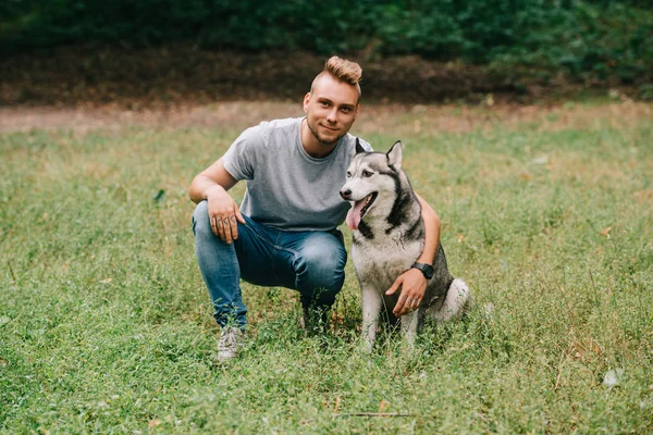 Young Man Hugging Siberian Husky Dog Park — Stock Photo, Image