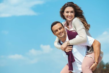 ile birlikte piggybacking çift arka plan üzerinde bulutlu gökyüzü mavi