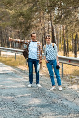 sırt çantaları ile çift ve yolda birlikte otostop göster