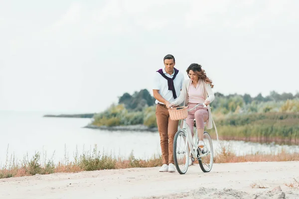 Man Helping Wife Ride Retro Bicycle Sandy Riverside — Stock Photo, Image