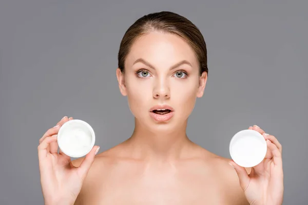 Retrato Mulher Chocada Com Cremes Faciais Frascos Isolados Cinza — Fotografia de Stock