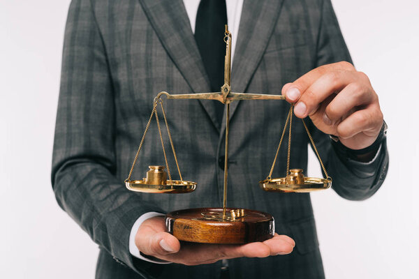 cropped image of businessman holding bronze scales isolated on white