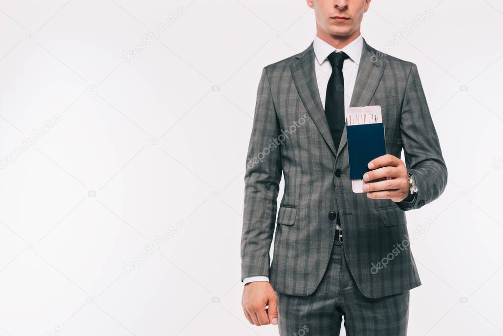 cropped image of businessman holding passport and ticket isolated on white