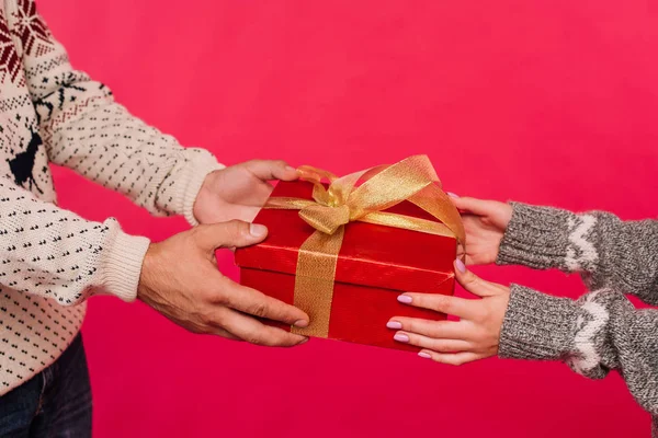 cropped image of boyfriend presenting gift to girlfriend isolated on pink
