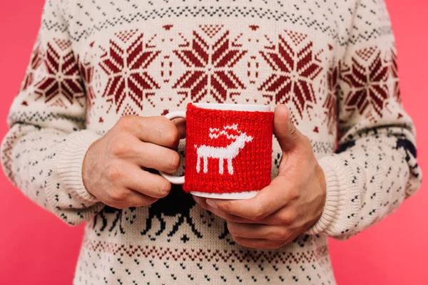 cropped image of man in sweater holding cup with deer silhouette isolated on pink