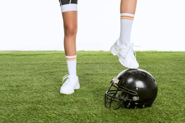 Amerikan futbol kask yeşil çimenlerin üzerinde beyaz izole üzerinde duran kadın kırpılmış atış
