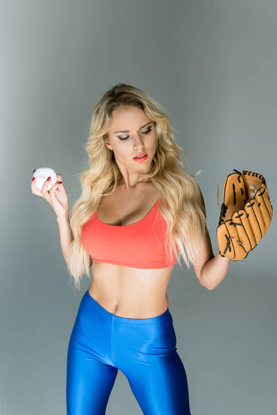 fit young woman in sportswear with baseball glove and ball 
