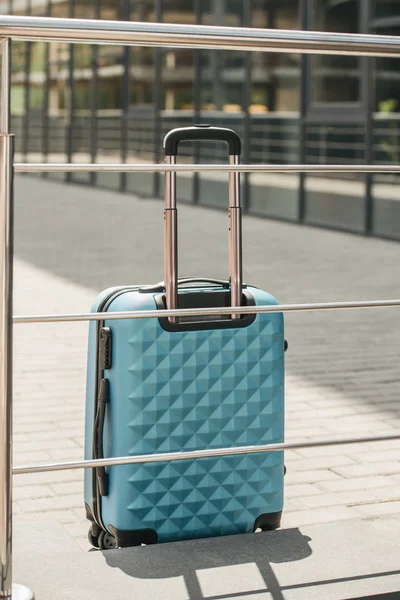 Hellblaue Reisetasche Neben Geländer Auf Straße — kostenloses Stockfoto