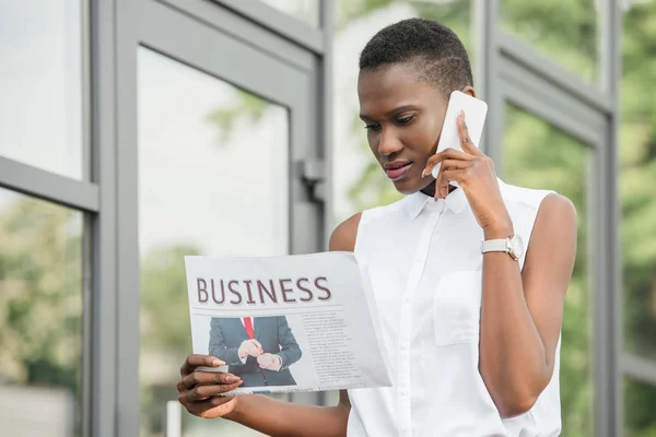 Stijlvolle Aantrekkelijke Afro Amerikaanse Zakenvrouw Praat Door Smartphone Leest Krant — Gratis stockfoto