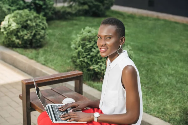 Veselý Stylový Atraktivní Africká Americká Podnikatelka Pomocí Přenosného Počítače Lavičce — Stock fotografie