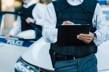 Erkek polis memuru Pano meslektaşı Street car yakınındaki ayakta iken yazma, kırpılmış görüntü