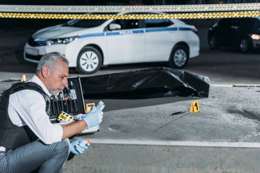 çapraz çizgi ceset torbası içinde ceset ile olay yerinde yakınındaki kanıt toplama polis yan görünüm 